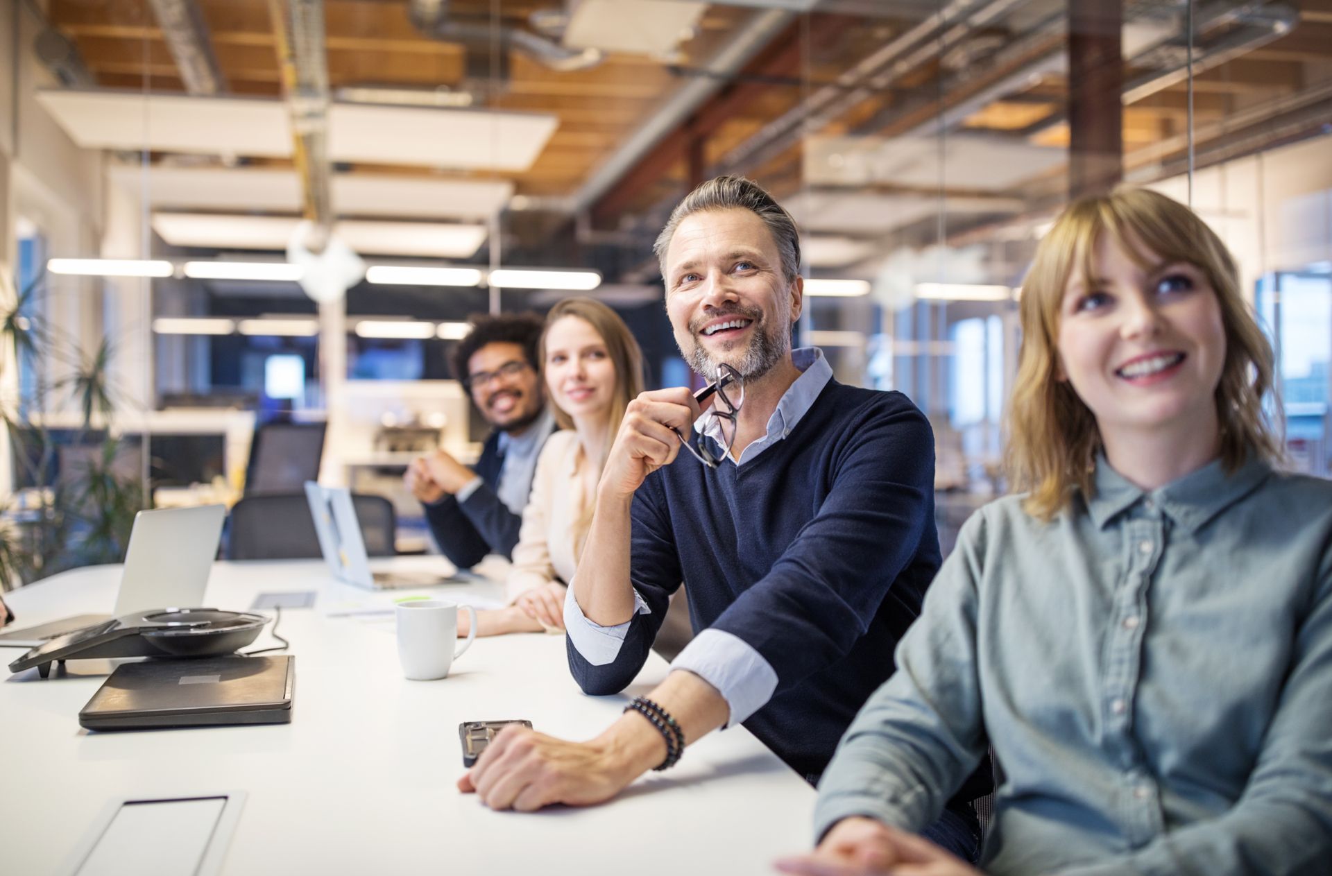 Group of employees sitting in an office working together on a modern communication solution.