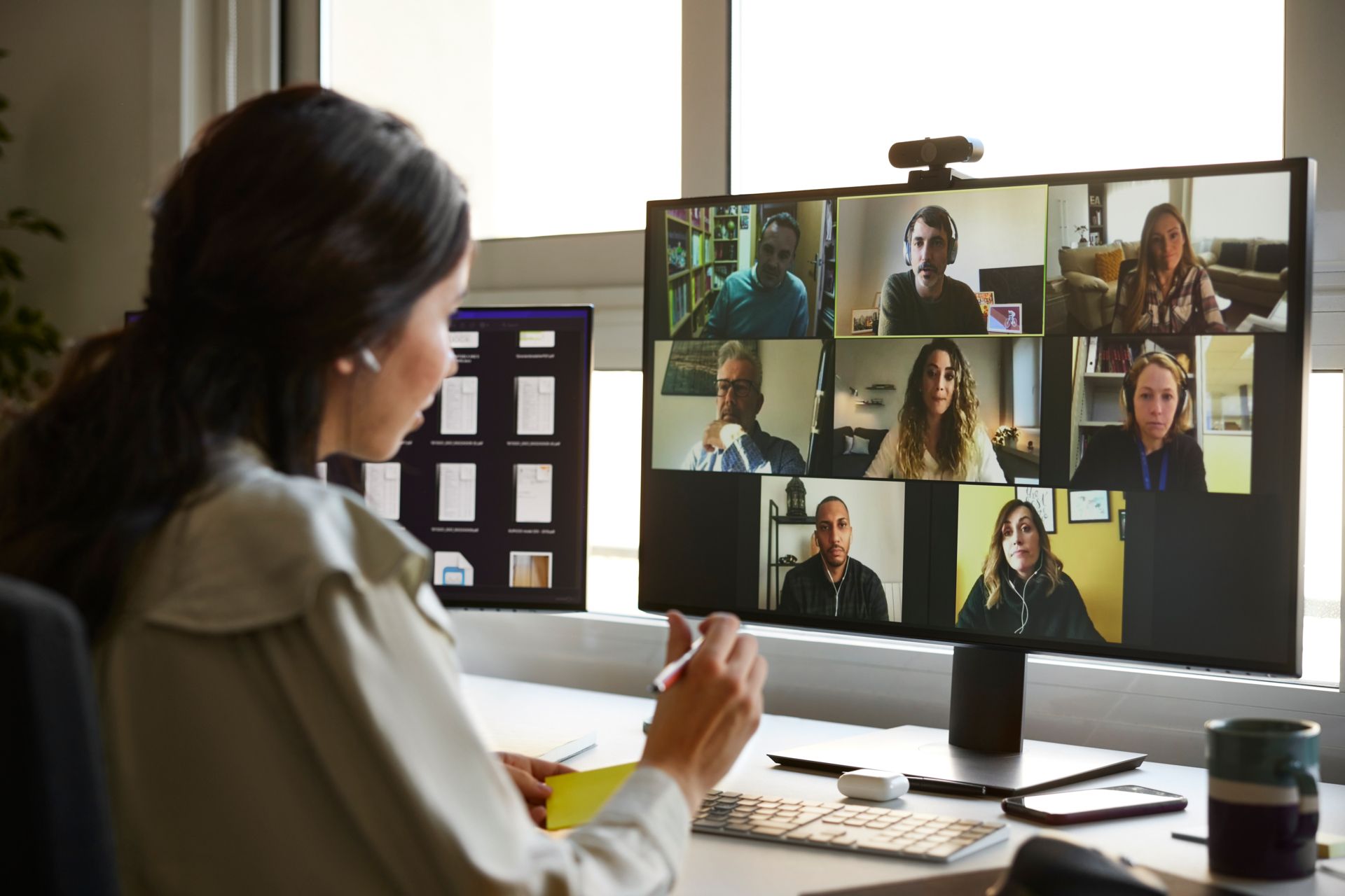 Woman looking at a computer screen in an office, possibly working remotely.